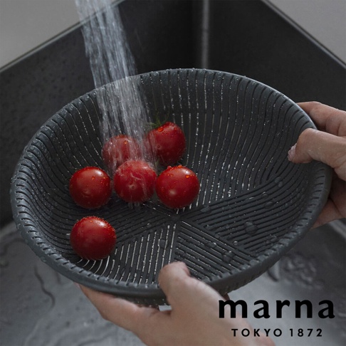 marna TOKYO 1872 品牌標誌旁的灰色濾水盆，盆內裝有幾顆小番茄，正被水龍頭沖洗。