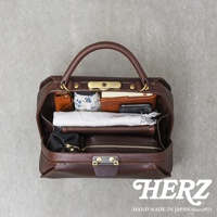 深棕色皮革手提包，內部裝有筆記本、錢包、手機、小包和一條毛巾。