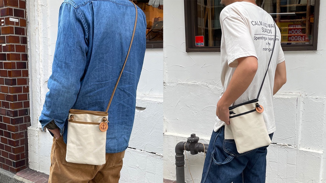 米白色帆布皮革散步包，附有皮革飾邊及一個船錨造型吊飾，可肩背或斜背。