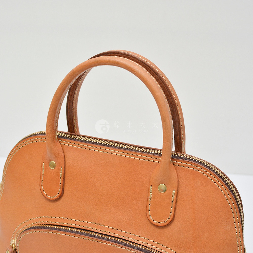 職人手作皮革兩用經典貝殼手提包，淺棕色皮革，圓弧形提把，雙層縫線，金色拉鍊，黃銅卯釘裝飾。