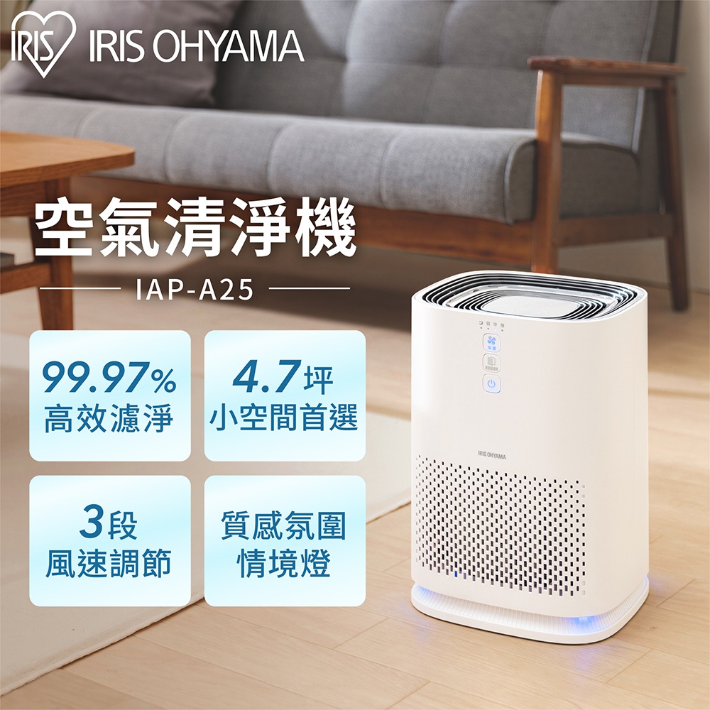 IRIS OHYAMA 情境式空氣清淨機 IAP-A25，白色圓角方形機身，頂部及側面有網狀出風孔，機身前方有品牌標誌及操作按鈕，底部有藍色燈光，置於客廳環境中。