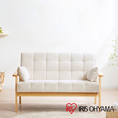 米白色實木雙人布沙發，帶有格子狀縫線設計，扶手與椅腳皆為木質原色，配有兩個小型白色抱枕。