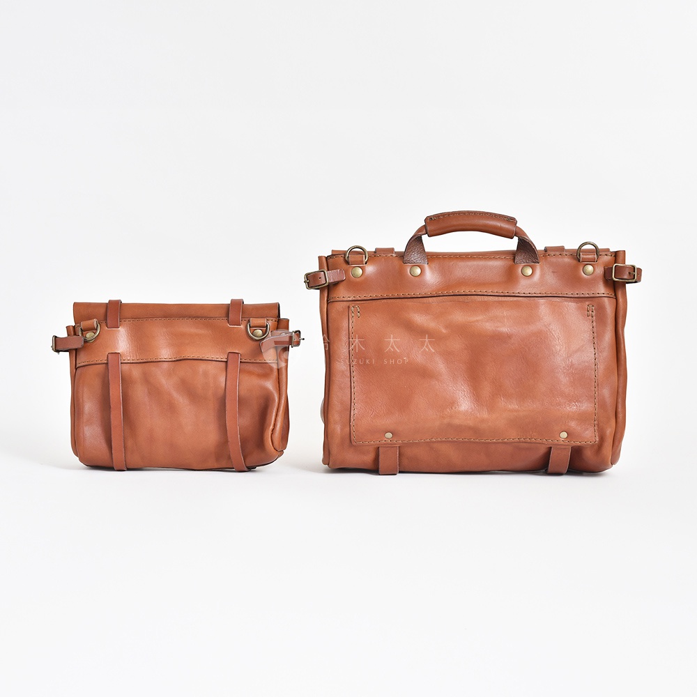 兩款棕色皮革復古郵差包，一款較小，一款較大，均採用水洗加工處理，帶有可調節的皮革肩帶和金屬扣件。