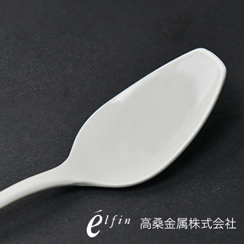 日製白琺瑯咖哩湯匙，光滑的白色琺瑯材質，湯勺部分呈現橢圓形，握柄較細長，背景為深灰色。