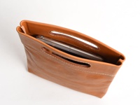 棕色皮革製直式收納袋，頂部有兩個橢圓形開口，袋內可見一個銀色平板電腦，袋身有白色縫線裝飾。