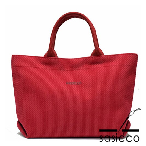 經典紅色三河木綿刺子織托特包，帶有圓形提把，包身織紋細緻，中央有品牌標誌。