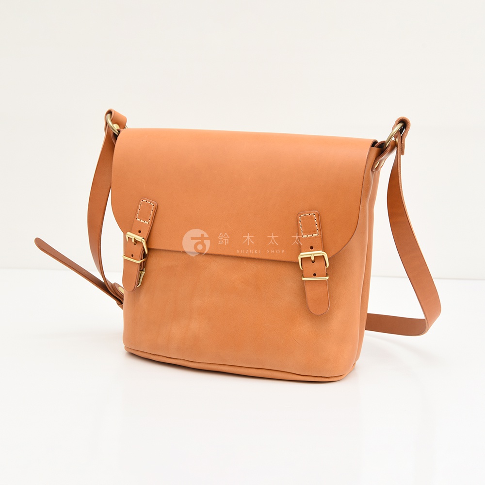 日本HERZ職人手作皮革雙扣旅行郵差包，焦糖色牛皮革材質，配有雙插釦開合設計，呈現簡約俐落的風格