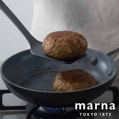 marna TOKYO 1872 品牌標誌和一個正在用黑色矽膠鍋鏟從鍋中取出烤漢堡肉餅的場景