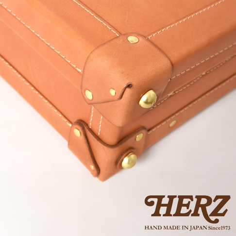 職人手作皮革英倫風便攜手提行李箱 TR-1，展示皮革邊角細節，採用棕褐色皮革，搭配白色縫線及黃銅色金屬铆釘，風格復古。