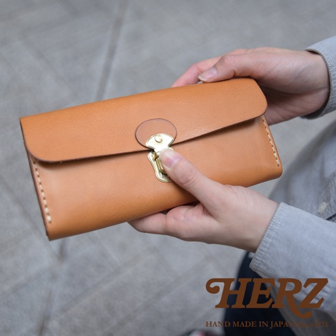 職人手作皮革長夾，淺棕色，配備金色鎖扣和手工縫線，手風琴式多卡層設計。