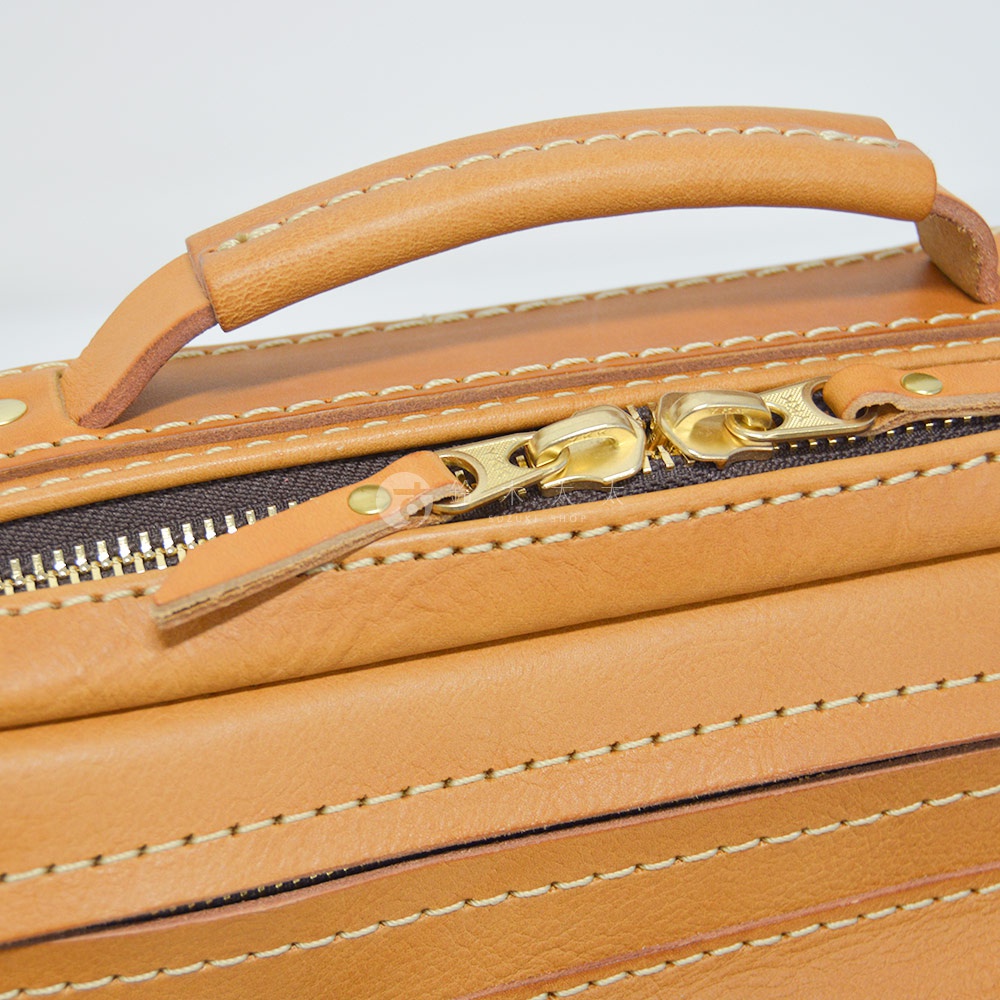 職人手作皮革兩用多功能收納單肩包 CW-96，展示皮革提把、金色拉鍊和縫線細節。