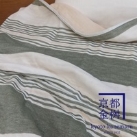 米白色與淺綠色條紋的六層紗材質毯子，材質柔軟，帶有文青風格。