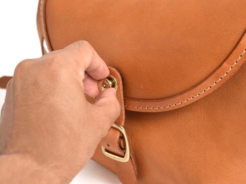 職人手作皮革休閒旅行馬鞍包 (CK-20)，採用天然棕色皮革製作，包包設有金屬旋轉鎖扣及皮帶扣，表面有細緻的縫線裝飾。