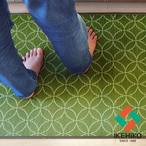 榻榻米廚房地墊，綠色織紋，帶有白色圓形幾何圖案，兩隻赤腳踩在上面。
