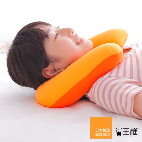 一名女子仰躺，頭部枕在一個橘色與亮橘色拼接的U型枕上。U型枕為軟質材質，呈現雙色設計。