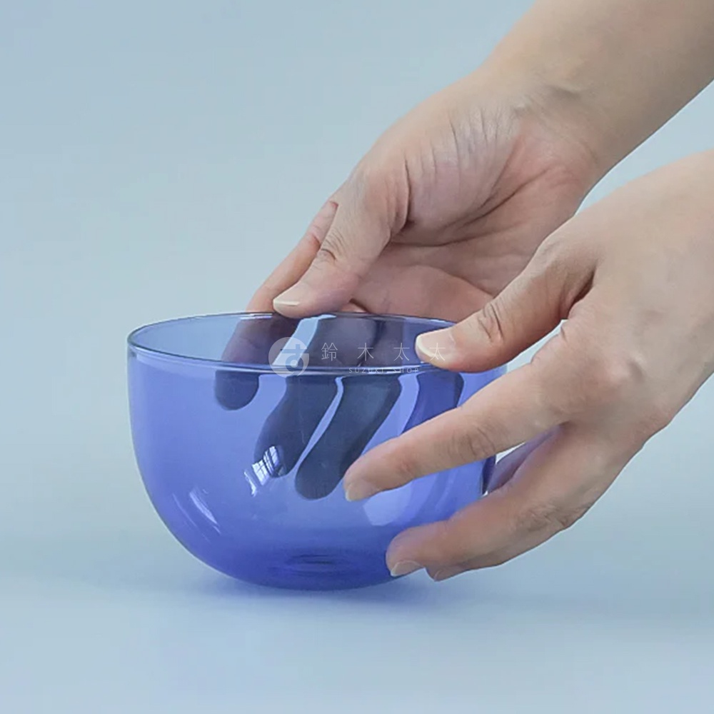 雙手捧著一個藍色透明的玻璃圓潤點心碗。