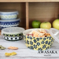 黃色陶瓷保鮮碗，飾有藍色小花圖案，碗內盛有各式義大利麵。旁邊還有數個附有透明蓋的保鮮碗，其中一個碗身有綠色和黑色的花紋。