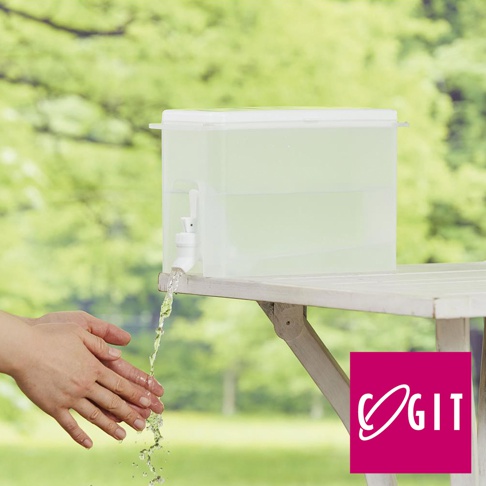 COGIT 品牌標誌在右下角的淺綠色透明冷飲壺，附有水龍頭，正在傾倒水流至下方的手中，背景是模糊的綠色樹木。