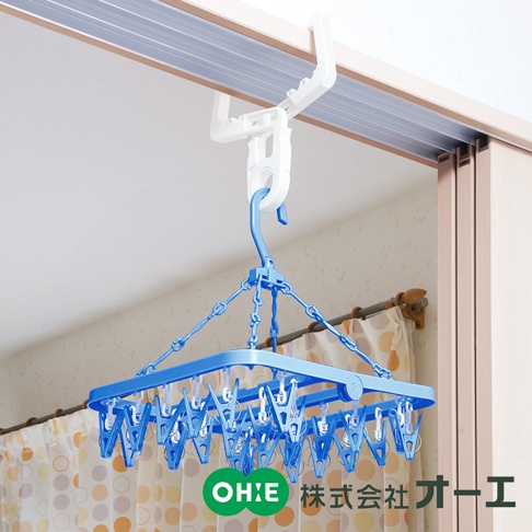 藍色方形晾掛組，附有數十個白色小夾子，透過藍色鏈條懸掛於白色門樑固定架上。