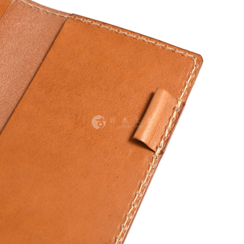 職人手作皮革輕便記事本書套，淺棕色皮革，內裡為較淺的棕褐色皮革，邊緣有縫線，右下角有一個皮革固定環。