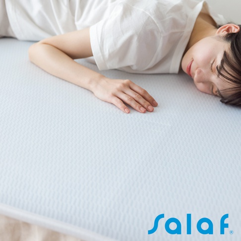 淺藍色紋理面料的單人睡墊，一位女性側臥於睡墊上，手部平放在睡墊表面。