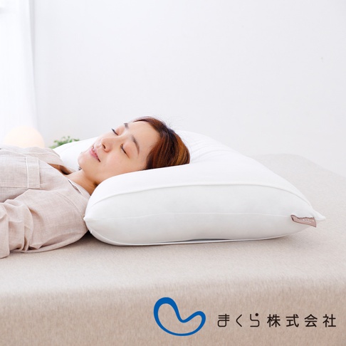 一位女性仰臥在白色無敵軟枕上，枕頭為白色，表面光滑，材質應為柔軟的織物。