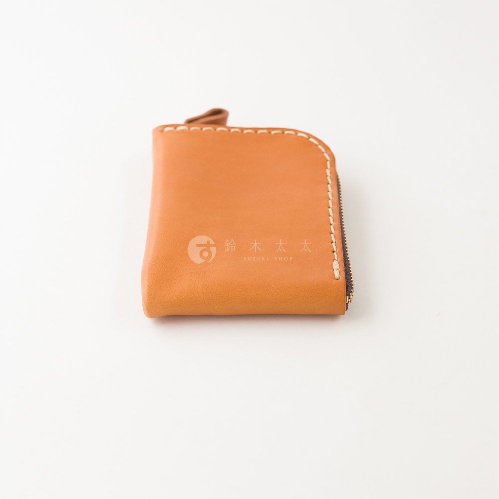 日本職人手作的淺棕色Stare皮革迷你錢包，錢包邊緣有淺色粗縫線設計，一側配置深色拉鍊，外觀簡約並印有鈴木太太品牌標誌，拍攝角度為側面俯視，背景為純淨的白色。