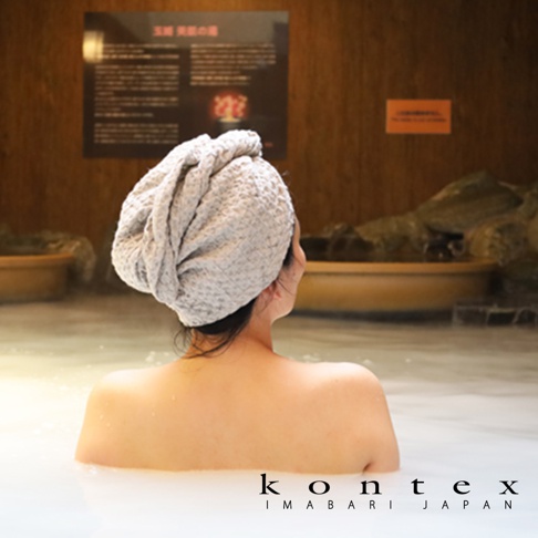 QULM 棉麻混紡包頭巾，淺灰色，有紋理，一位女士戴著包頭巾浸泡在溫泉中。