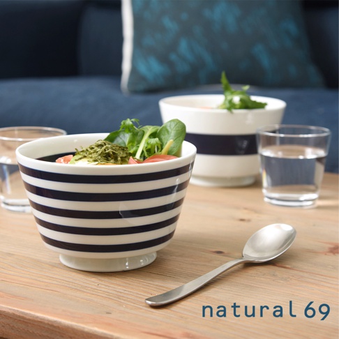 一個 navy blue 橫條紋陶瓷丼碗，盛有沙拉，旁邊有一個玻璃杯和一把銀色湯匙。