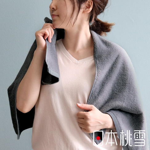 一位女性披著一條深灰色蓬鬆柔軟的純棉毛巾，毛巾質感細緻，邊緣有暗色滾邊。