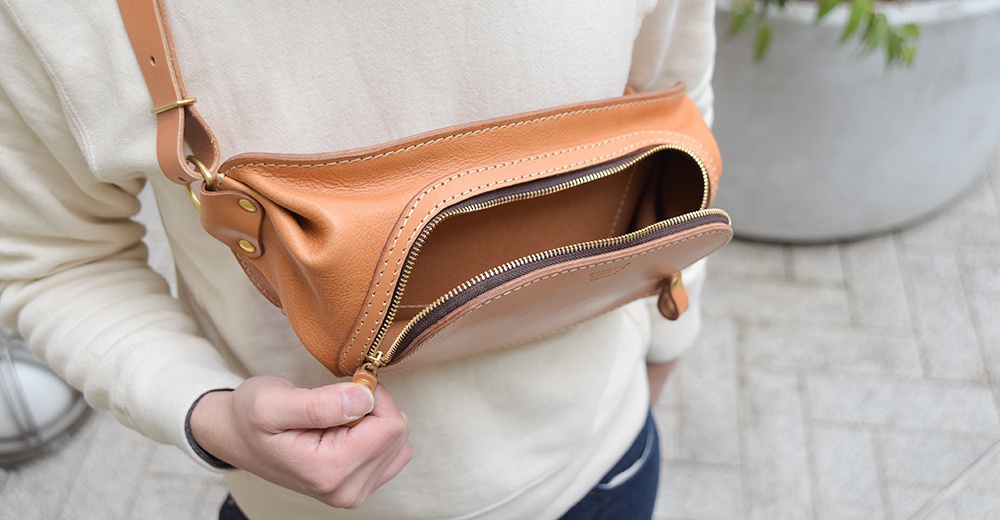 日本HERZ職人手作皮革拉鍊旅行斜背包，駝色皮革材質，拉鍊打開的狀態，展現內部空間。