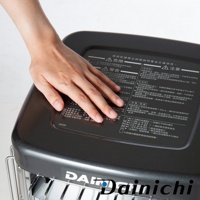 尊爵灰電子式煤油暖氣機頂部，手部覆蓋部分說明文字，顯示其金屬烤漆質感。