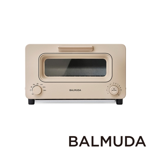 奶茶色烤麵包機，設有玻璃門和兩個旋鈕。左側旋鈕標示著不同的溫度和時間選項，右側旋鈕則有電源開關及時間刻度。機身上印有「BALMUDA」字樣。