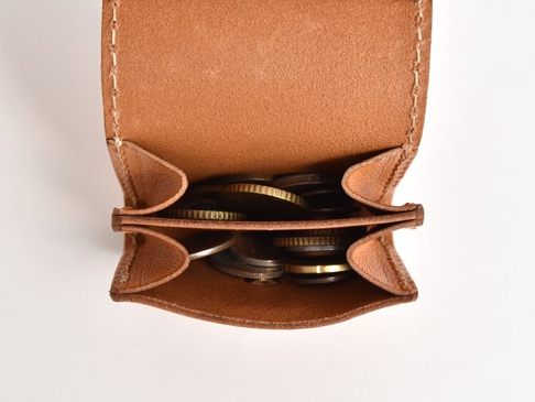 職人手作皮革雙折收納零錢包，呈現自然棕色皮革，內部裝有各式硬幣。包體結構清晰，縫線精緻，展現皮革的質感與實用性。