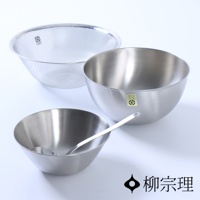 不鏽鋼調理盆組，包含一個帶有細密網孔的不鏽鋼瀝水籃，以及兩個不同尺寸的不鏽鋼調理盆，其中一個盆內放有一支不鏽鋼湯勺。