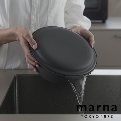 marna TOKYO 1872 品牌標誌，上方為一人手持深灰色洗濾盆，正將盆中的水瀝入水槽，水流清晰可見。