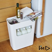 白色塑膠收納置物邊桌，頂部有淺盤，擺放著一瓶橄欖油、一罐香料和一本雜誌。桌身側面有簍空設計，可放入多瓶乳白色液體。