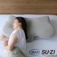 灰色側睡止鼾枕，具有凹槽設計，柔軟的織物表面，白色滾邊，一位女性正側臥於枕上。