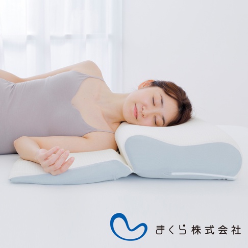 一名女子側臥，頭部枕於一個米白色和淺藍色相間的 15 度半身枕上，枕頭呈現人體工學的弧形設計，材質為柔軟織物。