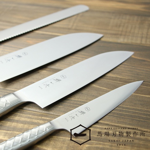 銀色不鏽鋼三德刀，刀身上印有品牌標誌和文字。其中一把刀的刀柄有菱形紋路。