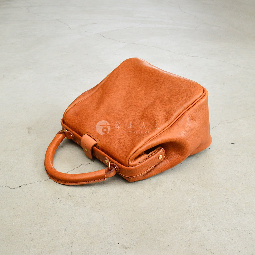 棕色皮革方形口金托特包，配有短提把和金屬扣環。