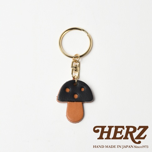 職人手作皮革香菇造型鑰匙圈，菌傘為黑色皮革，菌柄為棕色皮革，搭配金色鑰匙圈和鉤扣。