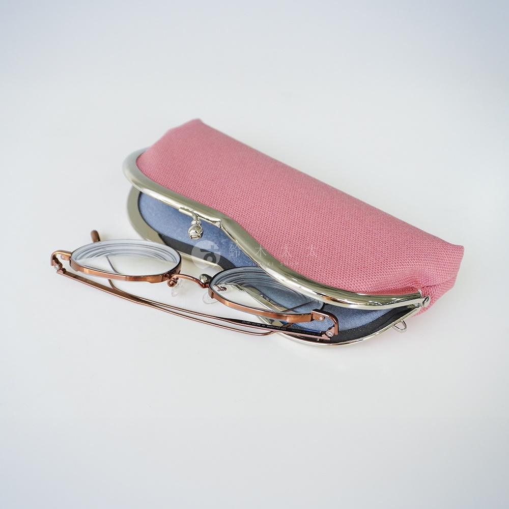 京都職人手作 AYANOKOJI 口金眼鏡收納盒，粉色布面搭配金色框，內有鏡片，放置於白色背景上。