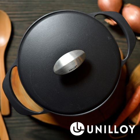 黑色琺瑯鑄鐵鍋，鍋蓋中央有銀色金屬提把，提把上刻有「UNILLOY」字樣。鍋身兩側有黑色鑄鐵把手，鍋內可見木質砧板。