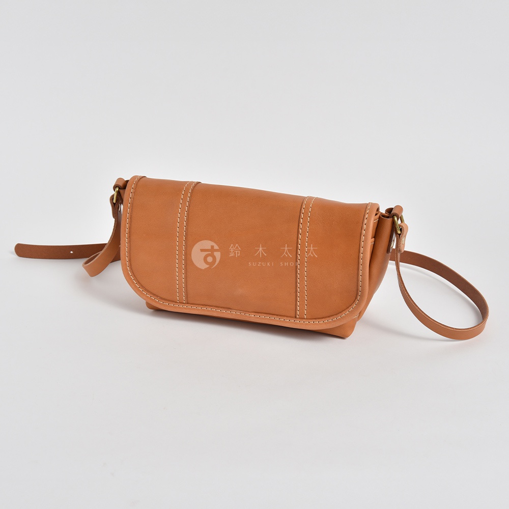 職人手作皮革復古郵差包 CM-100，採用淺棕色皮革製成，包身設計簡約，帶有精緻的縫線裝飾，可調節的長背帶，適合日常攜帶。
