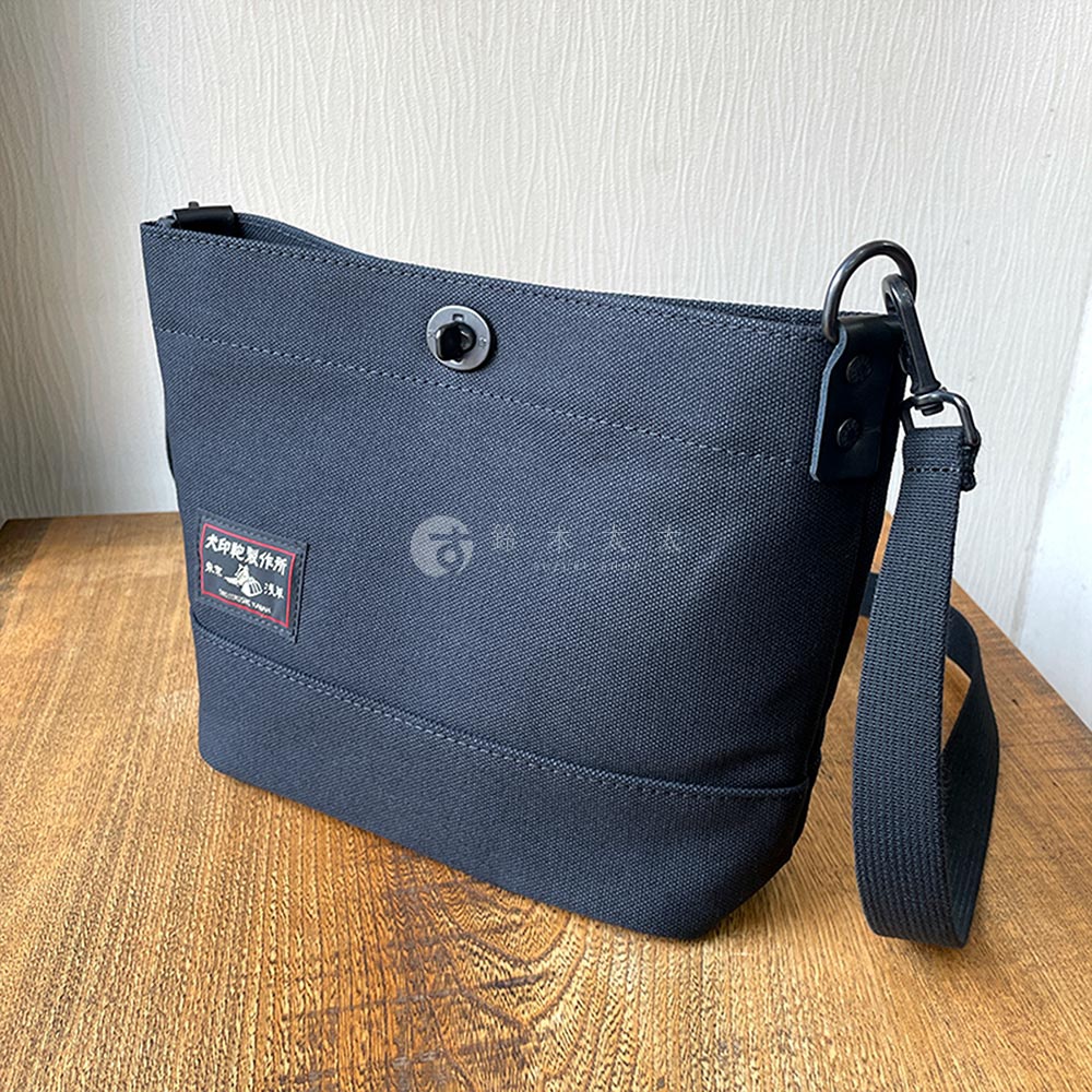 犬印鞄製作所黑色純綿帆布迷你側背包，帶有品牌標籤和可調節背帶