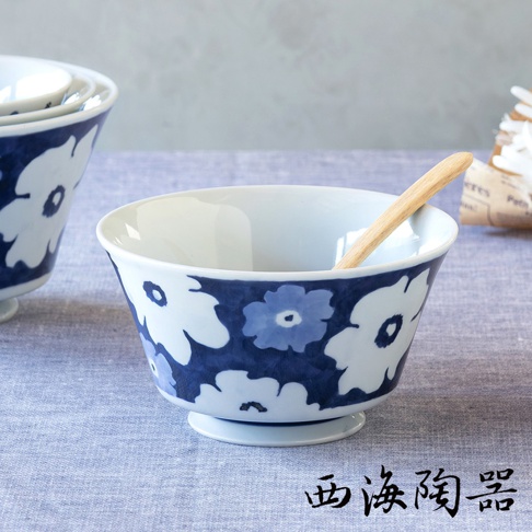 波佐見燒藍花紋多容量三件式丼飯碗，白色陶瓷碗身外緣繪有藍色與白色相間的花朵圖案，碗內有一支木質湯匙。