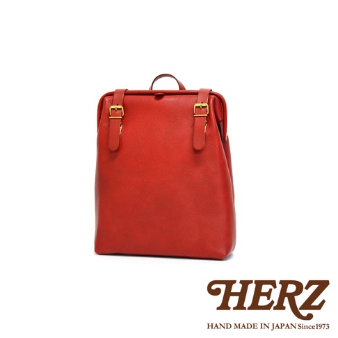 紅色皮革後背包 R-143，採用真皮材質，配有金色釦飾和搭帶，風格簡約，適合日常攜帶。