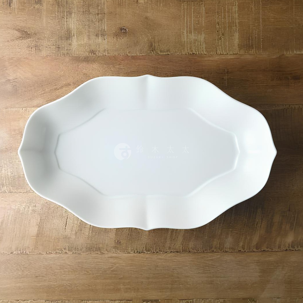 淡青白釉美濃燒輪花長盤，為白色陶瓷材質，盤緣呈現輪狀花瓣造型，盤面中央有品牌浮水印。