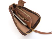 棕褐色皮革拉鍊短夾，內部有卡片夾層與零錢槽，展示有數張卡片和硬幣，搭配黃銅色拉鍊與同色系皮革拉繩。